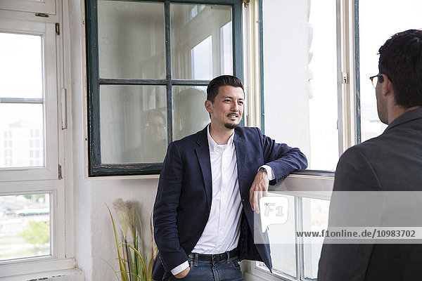 Two businessman standing at the window  talking
