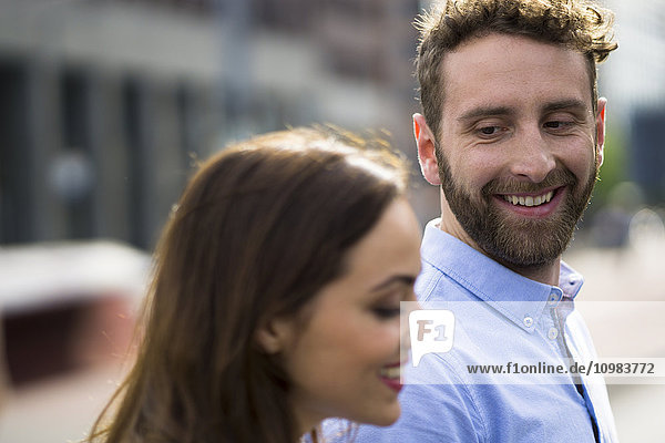Smiling young man looking at woman outdoors