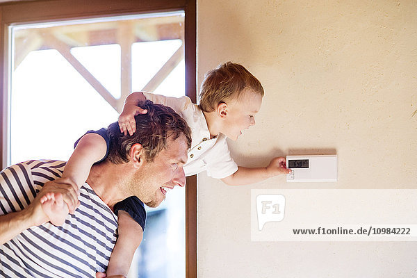 Vater trägt Sohn auf Schultern  Thermostat einstellen