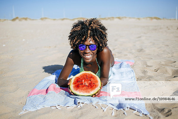 Glückliche junge Frau mit Wassermelone am Strand