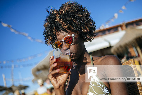 Junge Frau bei einem Drink in einer Strandbar