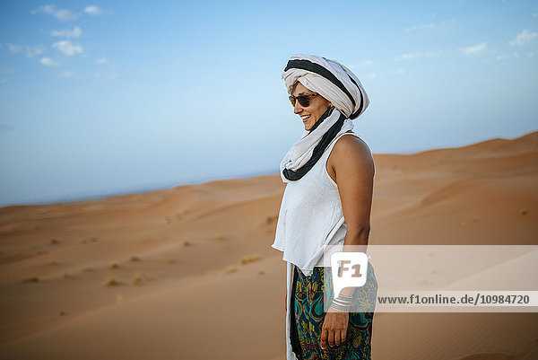 Frau steht in der Wüste  trägt Turban
