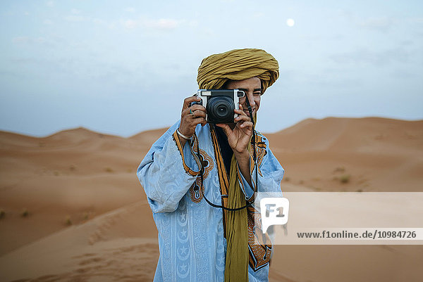 Young Berber taking pictures with camera