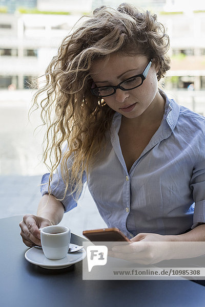 Geschäftsfrau beim Telefonieren im Outdoor-Café