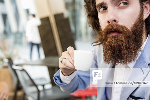 Stylish businessman drinking espresso in a cafe