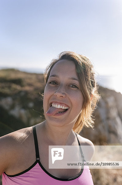Spanien  Asturien  Porträt einer Sportlerin  lächelnd  Zunge herausstreckend