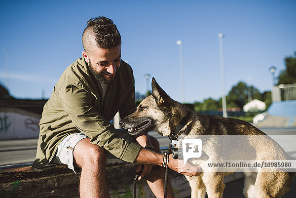 Mann mit Hund im Skatepark