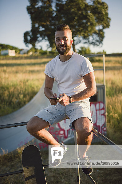 Porträt eines lächelnden Skateboardfahrers im Skatepark