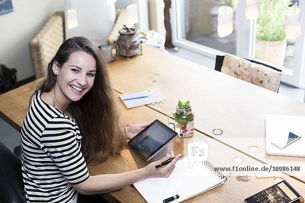 Porträt einer glücklichen jungen Frau mit digitalem Tablett
