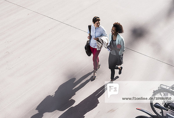 Two businesswomen walking and talking  seen from above