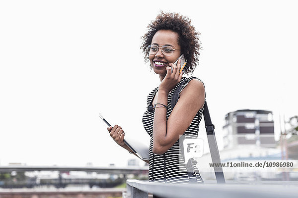Smiling businesswoman telephoning with cell phone
