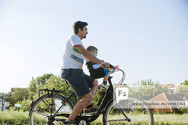 Little boy on bicycle tour with his father