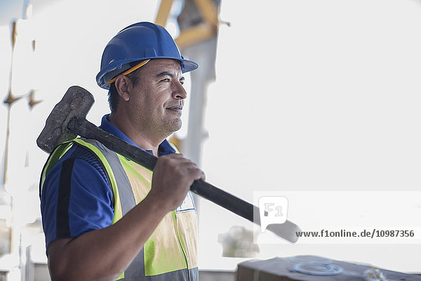 Confident construction worker with sledgehammer