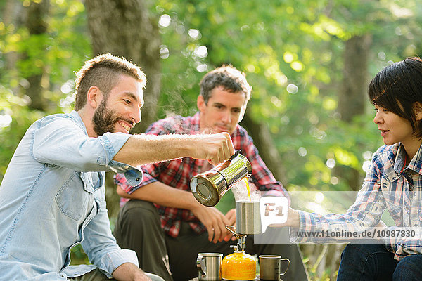 Multiethnische Gruppe von Freunden beim Kaffee auf einem Campingplatz