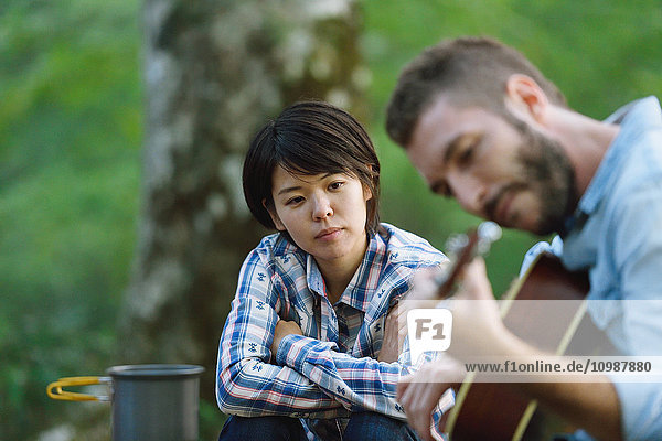Freunde spielen Gitarre auf einem Campingplatz