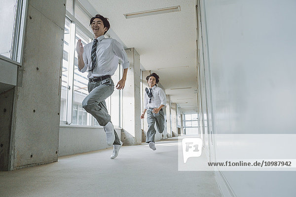 Japanische Gymnasiasten rennen durch den Schulflur