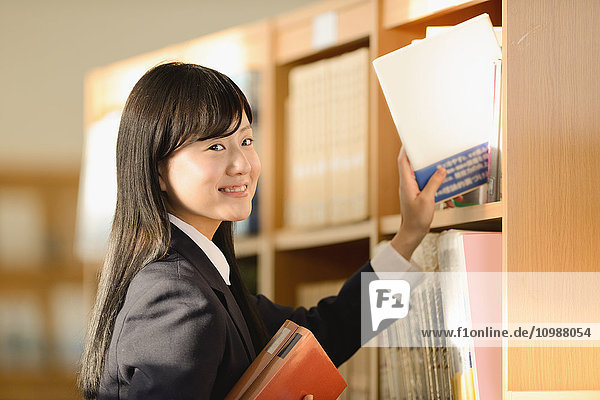 Japanische Oberschülerin in der Schulbibliothek