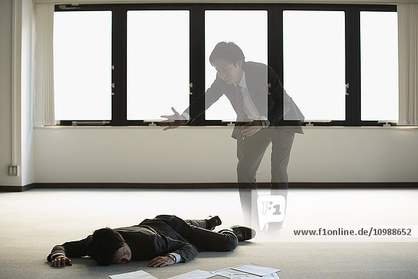 Young Japanese businessman dead on the floor of an empty office