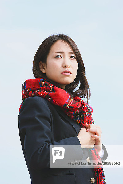 Japanese high-school student with scarf against blue sky