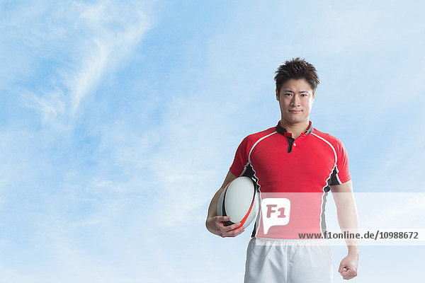 Porträt eines japanischen Rugbyspielers mit Ball