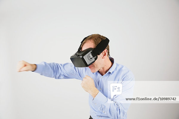 Kaukasischer Mann  der ein Virtual-Reality-Gerät benutzt