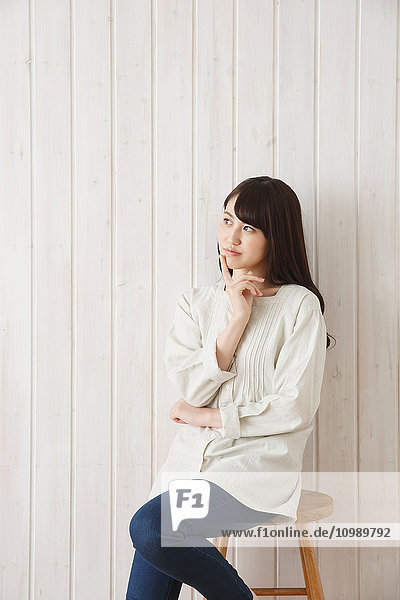 Young Japanese woman against wooden wall