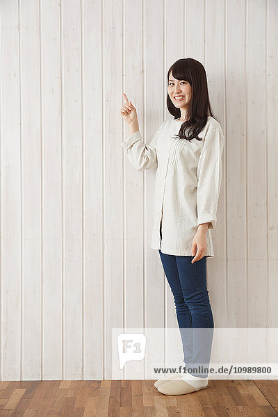 Young Japanese woman against wooden wall