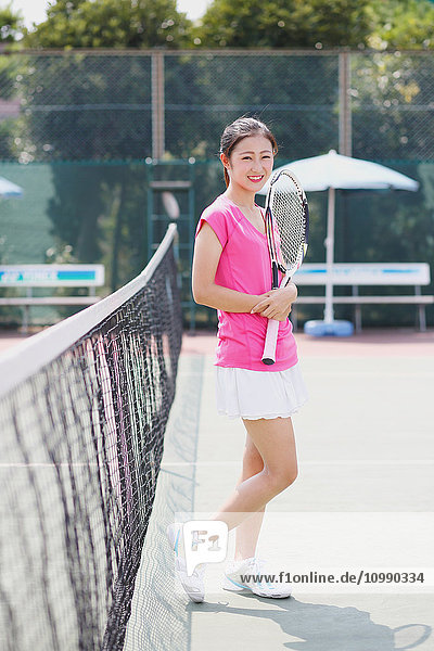 Junge japanische Tennisspielerin auf dem Platz
