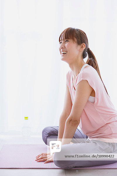 Young Japanese woman relaxing after practicing yoga