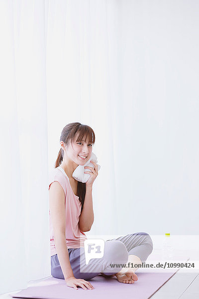 Young Japanese woman relaxing after practicing yoga