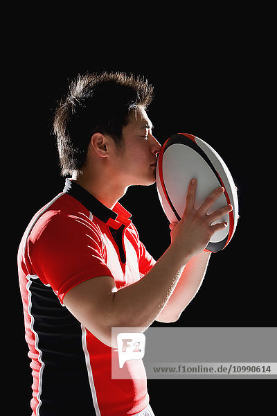 Porträt eines japanischen Rugbyspielers mit Ball