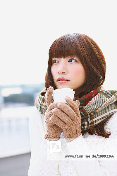 Attraktive Japanerin mit Kaffee an einem Wintertag
