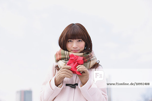 Attraktive japanische Frau mit Geschenk an einem Wintertag