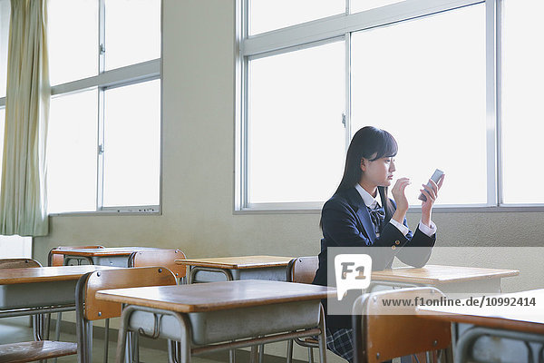 Japanische Schülerin in leerem Klassenzimmer
