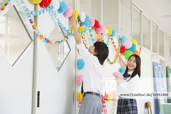Japanische Gymnasiasten in einem dekorierten Schulflur
