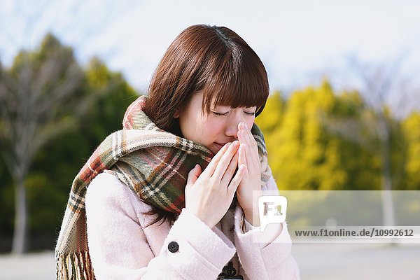 Attraktive japanische Frau  die sich an einem Wintertag krank fühlt