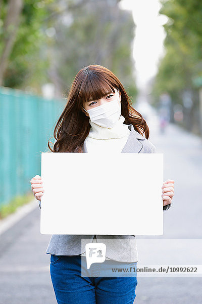 Attraktive Japanerin mit Whiteboard an einem Wintertag