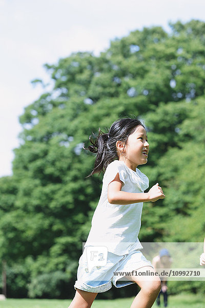 Japanese kid running in a city park