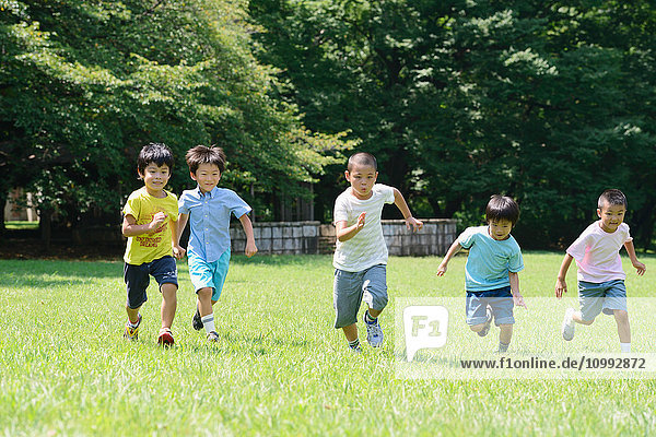 Japanese kids running in a city park