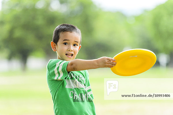 Kind spielt mit Freesbee in einem Park