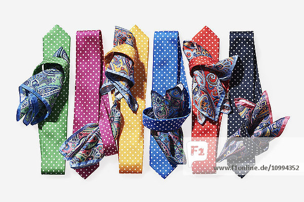 Sechs  farbige Krawatten mit Taschentüchern auf weißem Hintergrund im Atelier