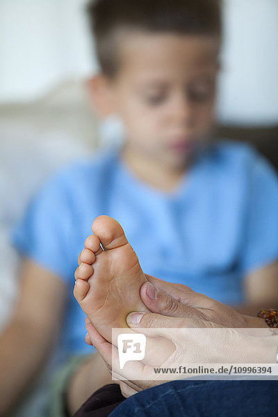 Reportage über Fußreflexzonenmassage bei Kindern. Der Fußreflexologe behandelt Kinder ab dem Alter von 5 Jahren aufwärts. Die Fußreflexzonenmassage wirkt sich auf ihre Konzentration  ihr Gedächtnis  ihr Gleichgewicht  ihre Gelassenheit und ihren Schlaf aus. Ein 5 Jahre alter Junge in einer Sitzung.