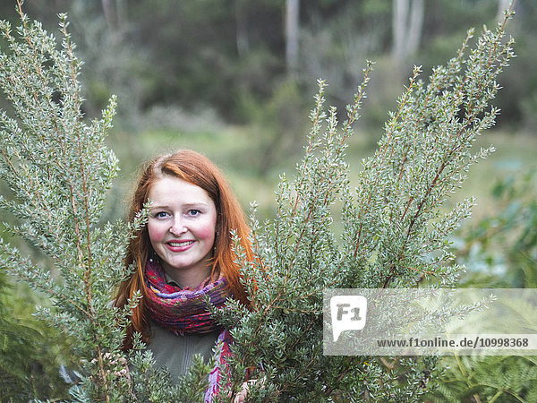 Portrait of smiling redhead in bushes
