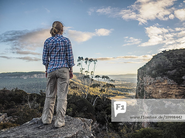 Australia  New South Wales  Blue Mountains  Blackheath  Megalong Valley  Mature woman standing on rock and looking at valley below