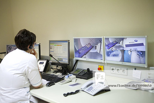 Reportage at the Rinecker Proton Therapy Center in Munich  Germany. The centre has the latest equipment for proton therapy treatment. Proton therapy involves irradiating cancer cells by concentrating a proton beam on the heart of the tumour  while preserving the healthy surrounding tissue. A technician monitors a treatment session from the control room.