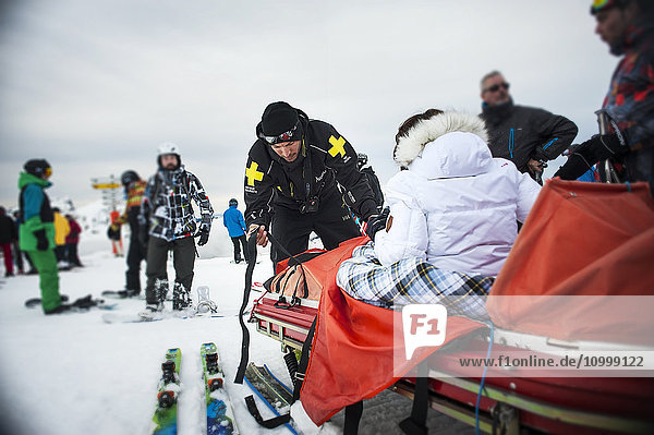 Reportage with a ski patrol team at the Avoriaz ski resort in Haute Savoie  France. The team are responsible for marking out the ski slopes  providing first aid to skiers  evacuations on the slopes as well as off piste and controlled avalanches. The patrol team evacuate a woman who has injured her knee.