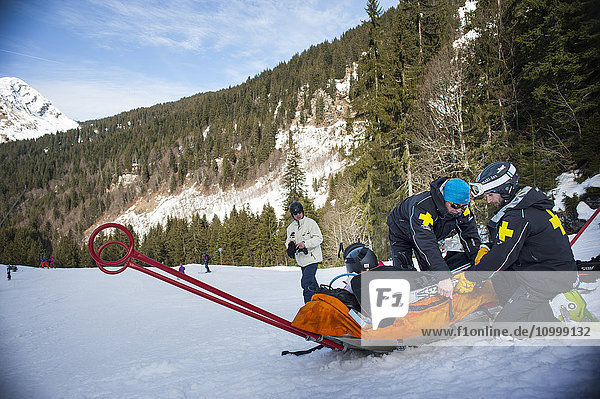 Reportage with a ski patrol team at the Avoriaz ski resort in Haute Savoie  France. The team are responsible for marking out the ski slopes  providing first aid to skiers  evacuations on the slopes as well as off piste and controlled avalanches. The patrol team evacuate a man who has a shoulder injury.