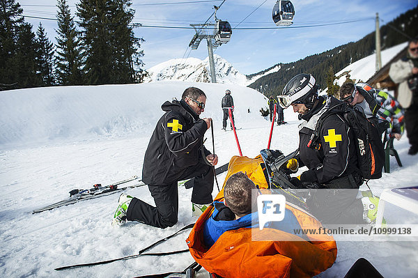 Reportage with a ski patrol team at the Avoriaz ski resort in Haute Savoie  France. The team are responsible for marking out the ski slopes  providing first aid to skiers  evacuations on the slopes as well as off piste and controlled avalanches. The patrol team evacuate a man who has a shoulder injury.