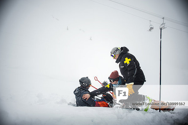 Reportage with a ski patrol team at the Avoriaz ski resort in Haute Savoie  France. The team are responsible for marking out the ski slopes  providing first aid to skiers  evacuations on the slopes as well as off piste and controlled avalanches. The ski patrol team rescue a snowboarder who has injured his shoulder.