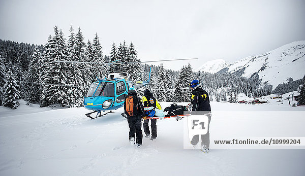 Reportage with a ski patrol team at the Avoriaz ski resort in Haute Savoie  France. The team are responsible for marking out the ski slopes  providing first aid to skiers  evacuations on the slopes as well as off piste and controlled avalanches. The patrol team evacuate a woman by helicopter who has a shoulder injury.